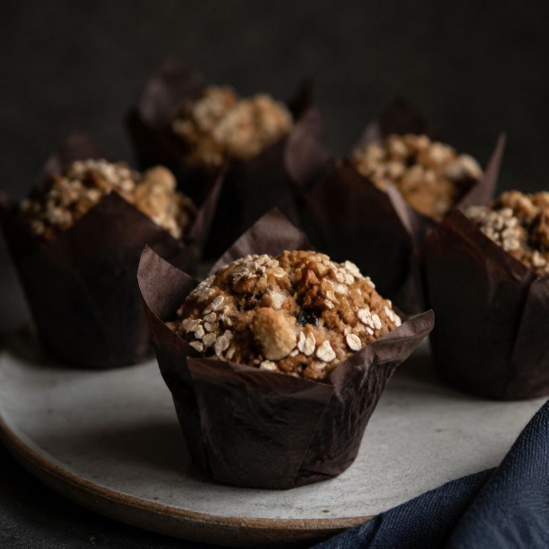 Oat-topped breakfast muffins in dark paper cases